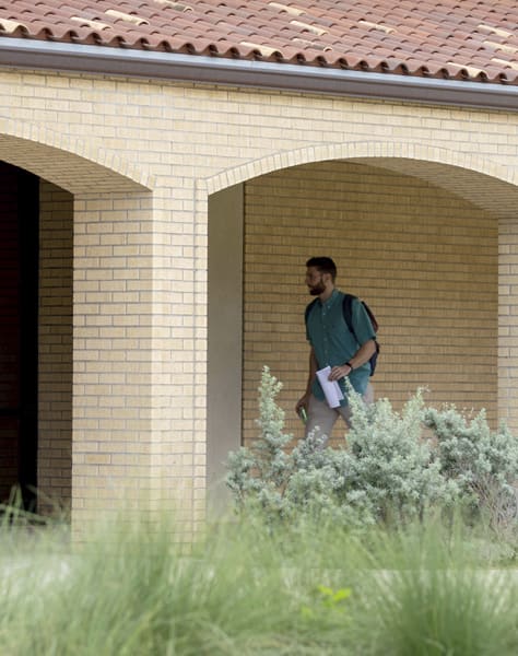man walking in front of library