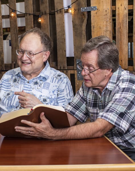 Dr. Harris and Dr. Chisholm looking at a Bible