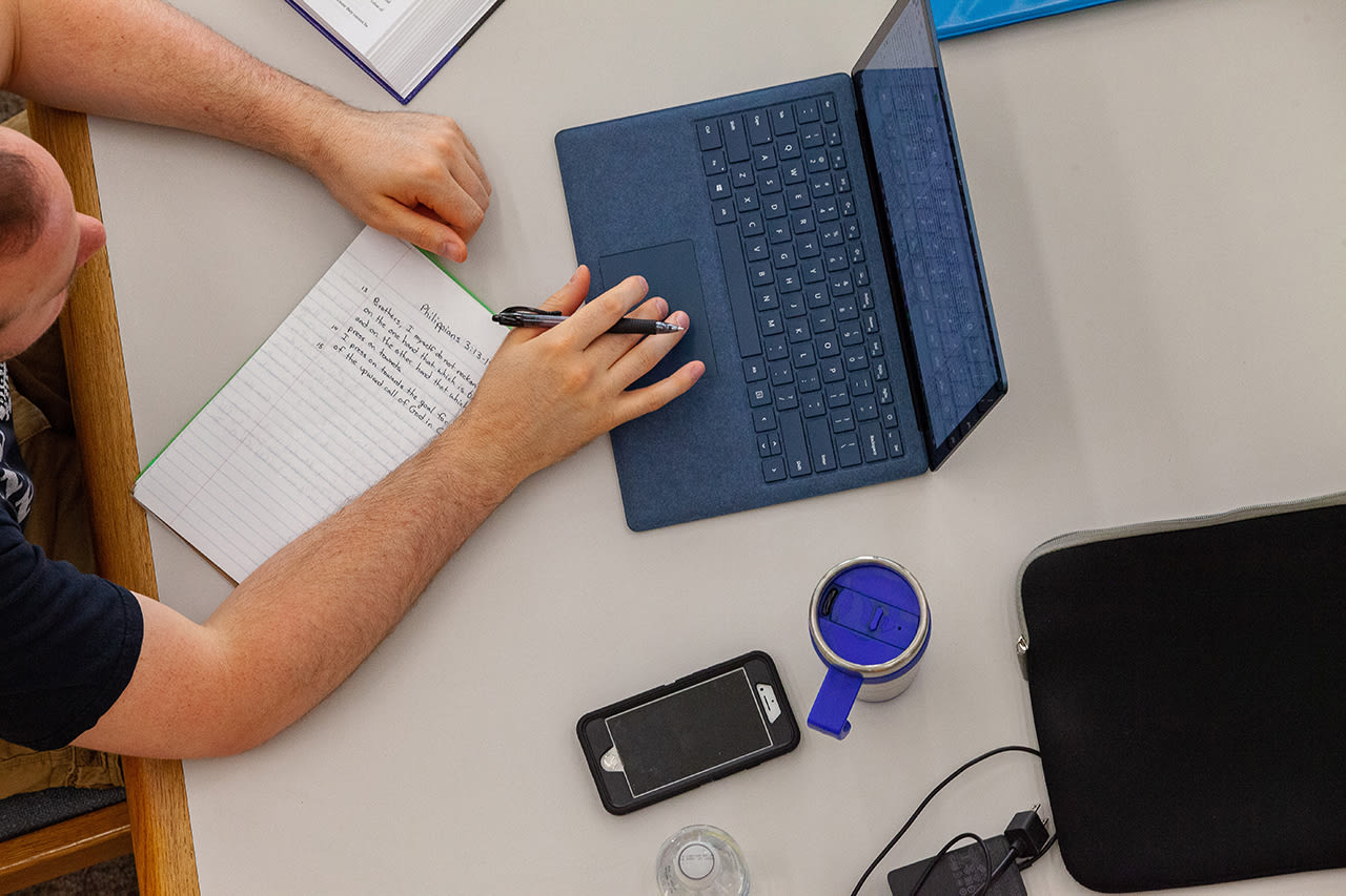 overhead shot of guy studying on his computer