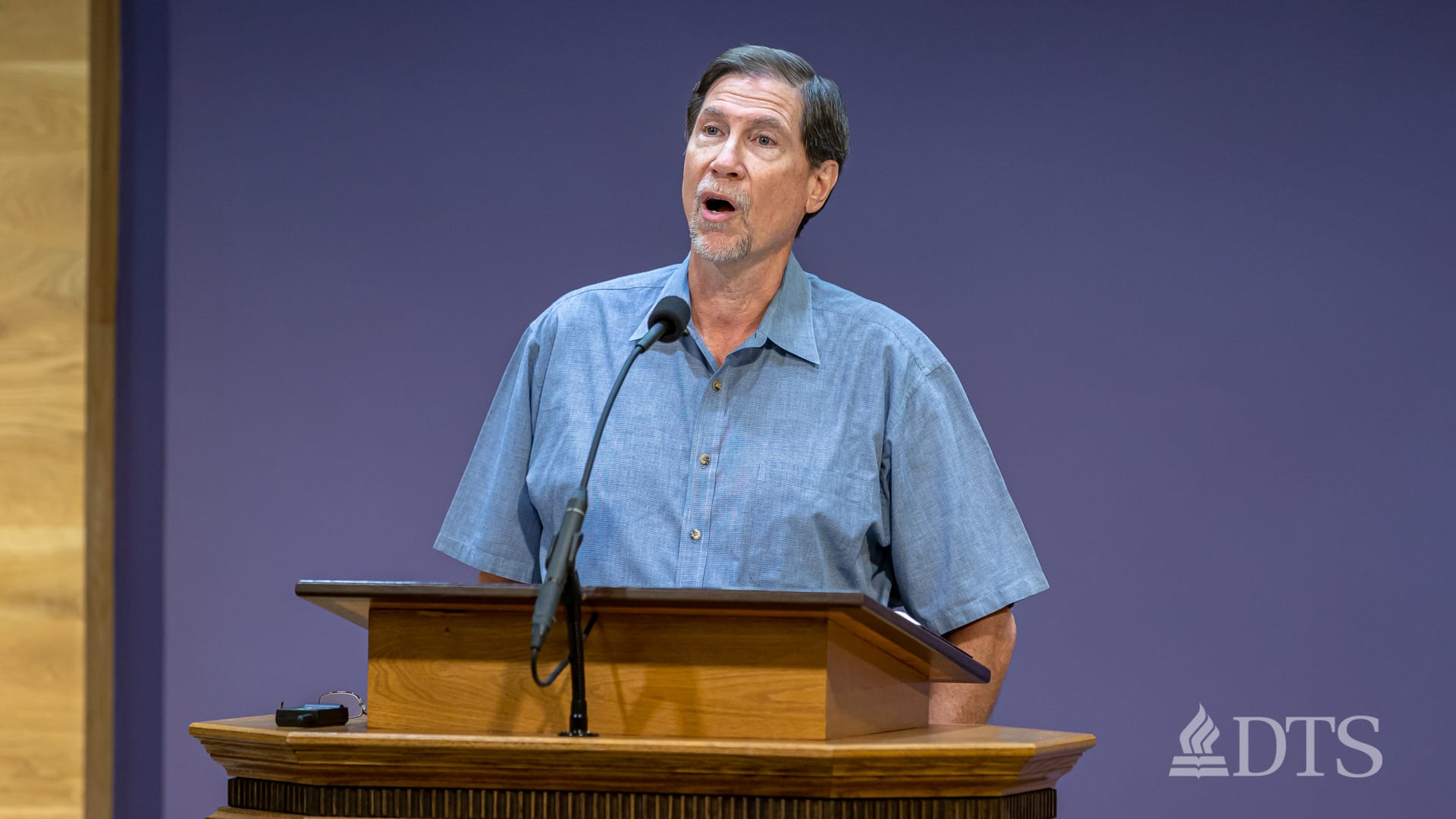 Dr. Jim Thames standing at a podium speaking into a microphone