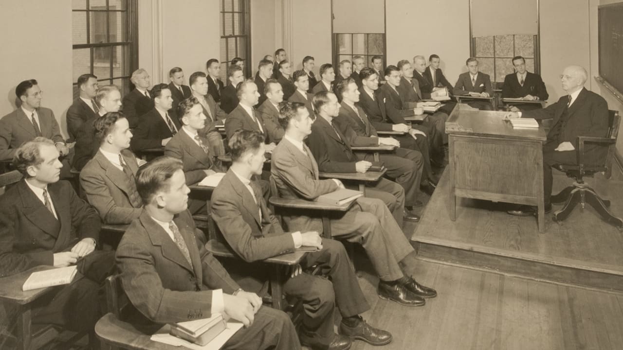 Professor at desk teaching students
