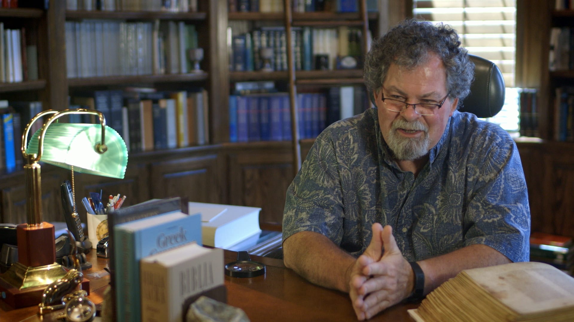 Dr. Wallace seated at his desk surrounded by books