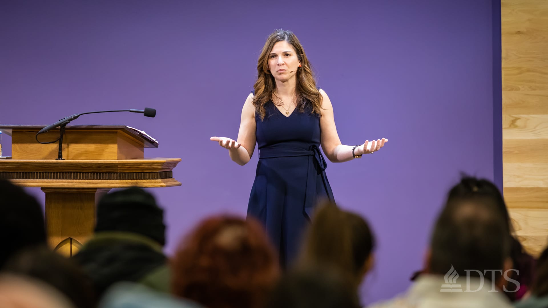woman standing next to podium speaking at DTS Chapel