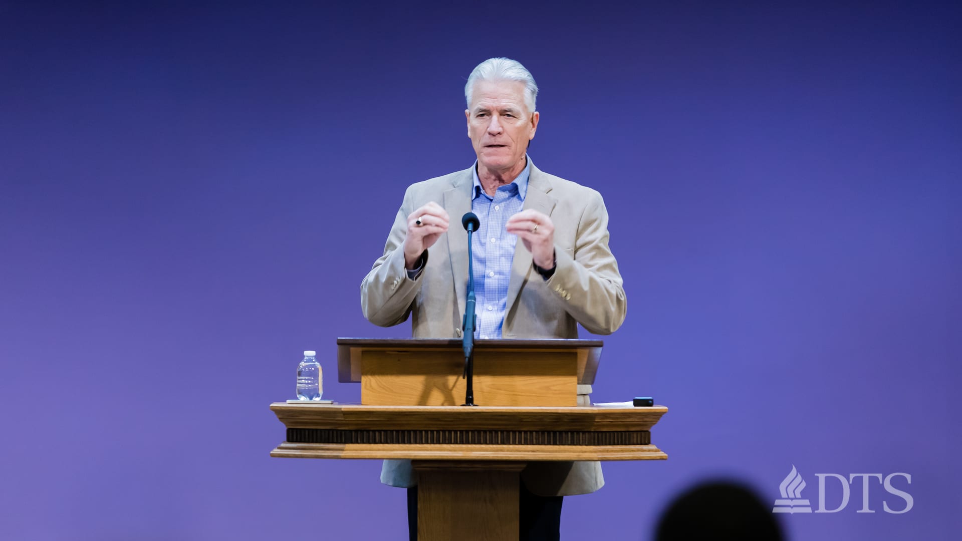 man standing at podium speaking at DTS Chapel