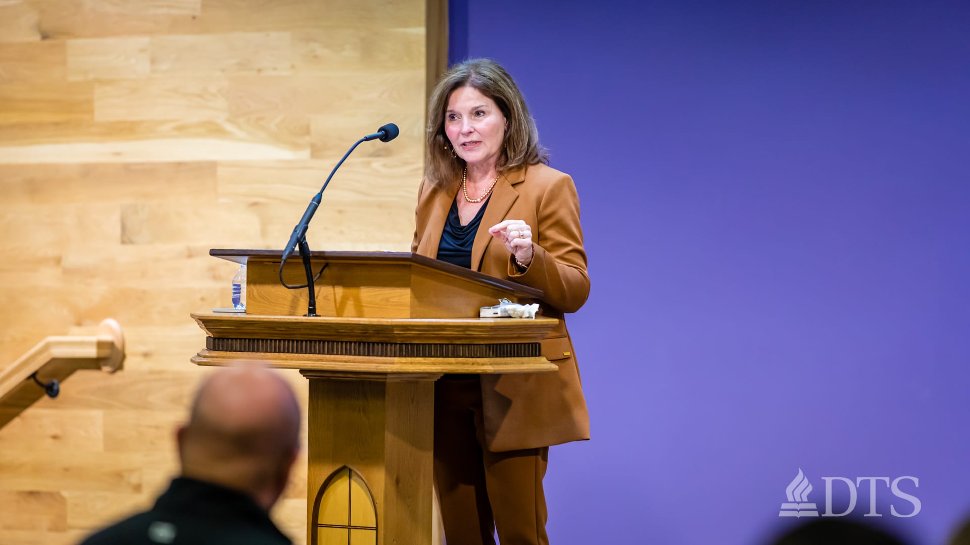 woman standing at podium speaking at DTS Chapel