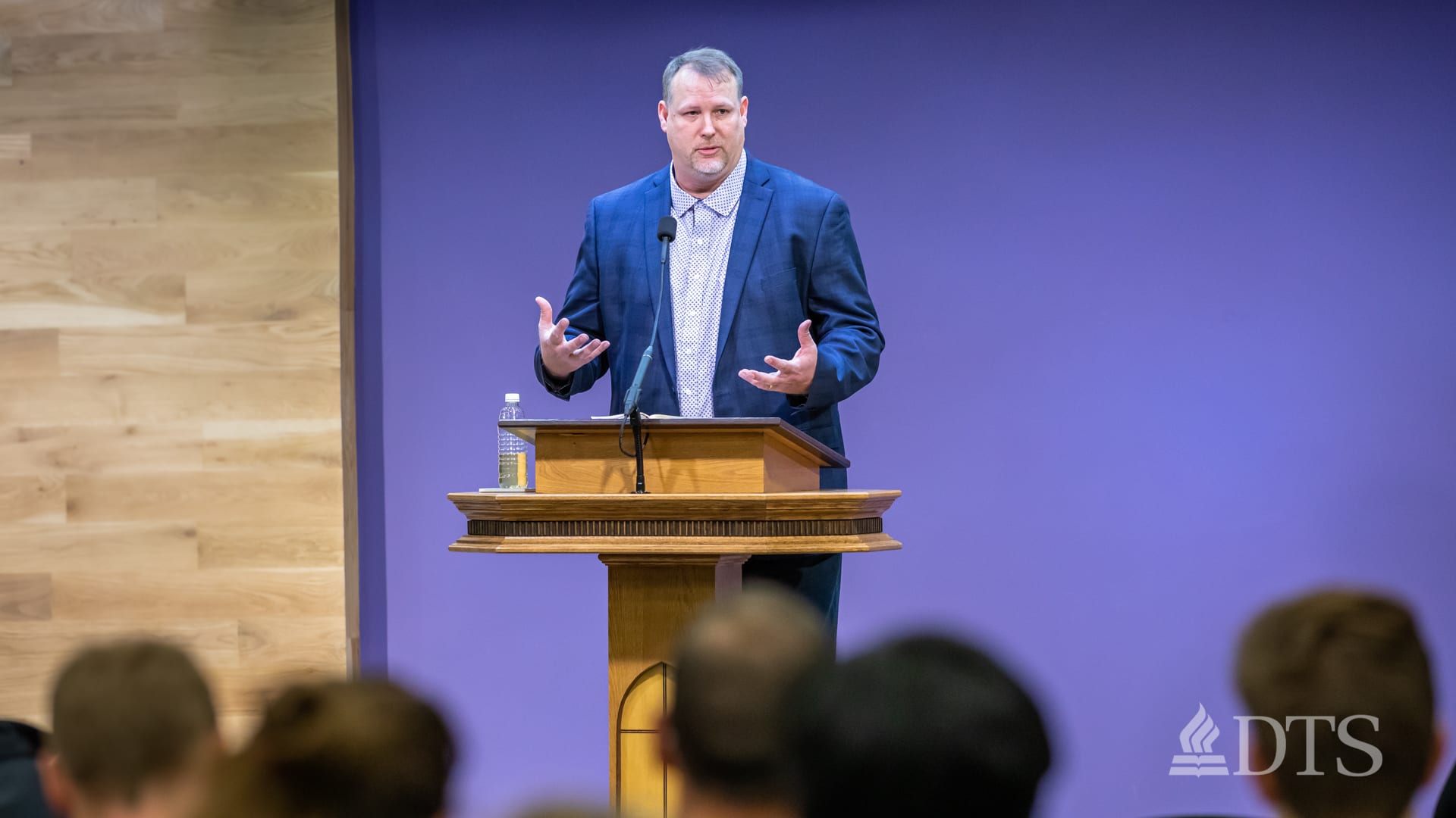 man standing at podium speaking at DTS Chapel