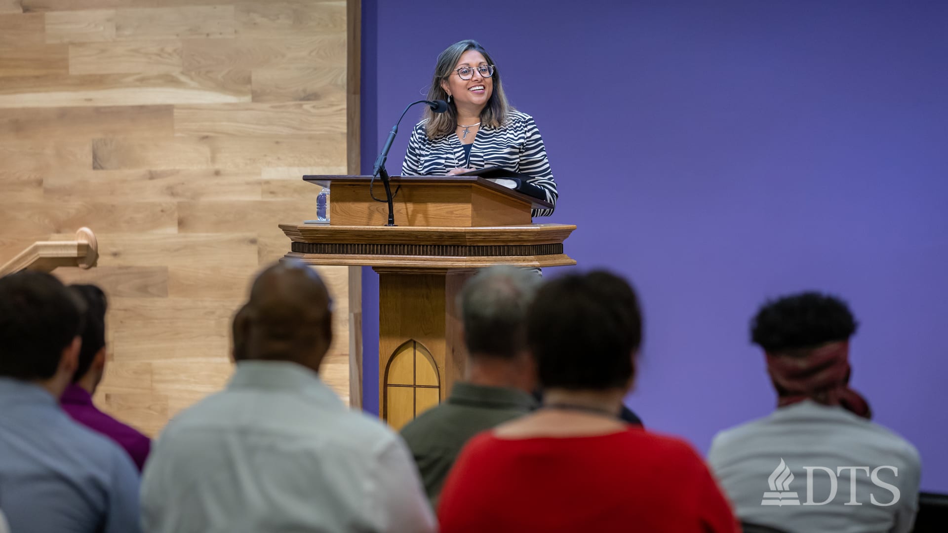 woman standing at podium speaking at DTS Chapel