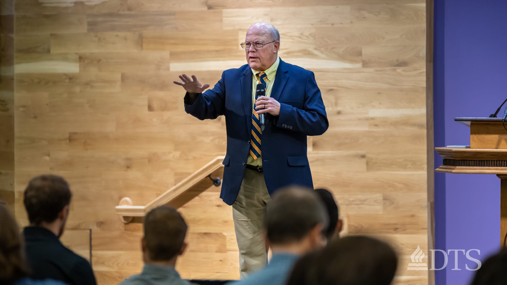 man standing next to podium speaking at DTS Chapel