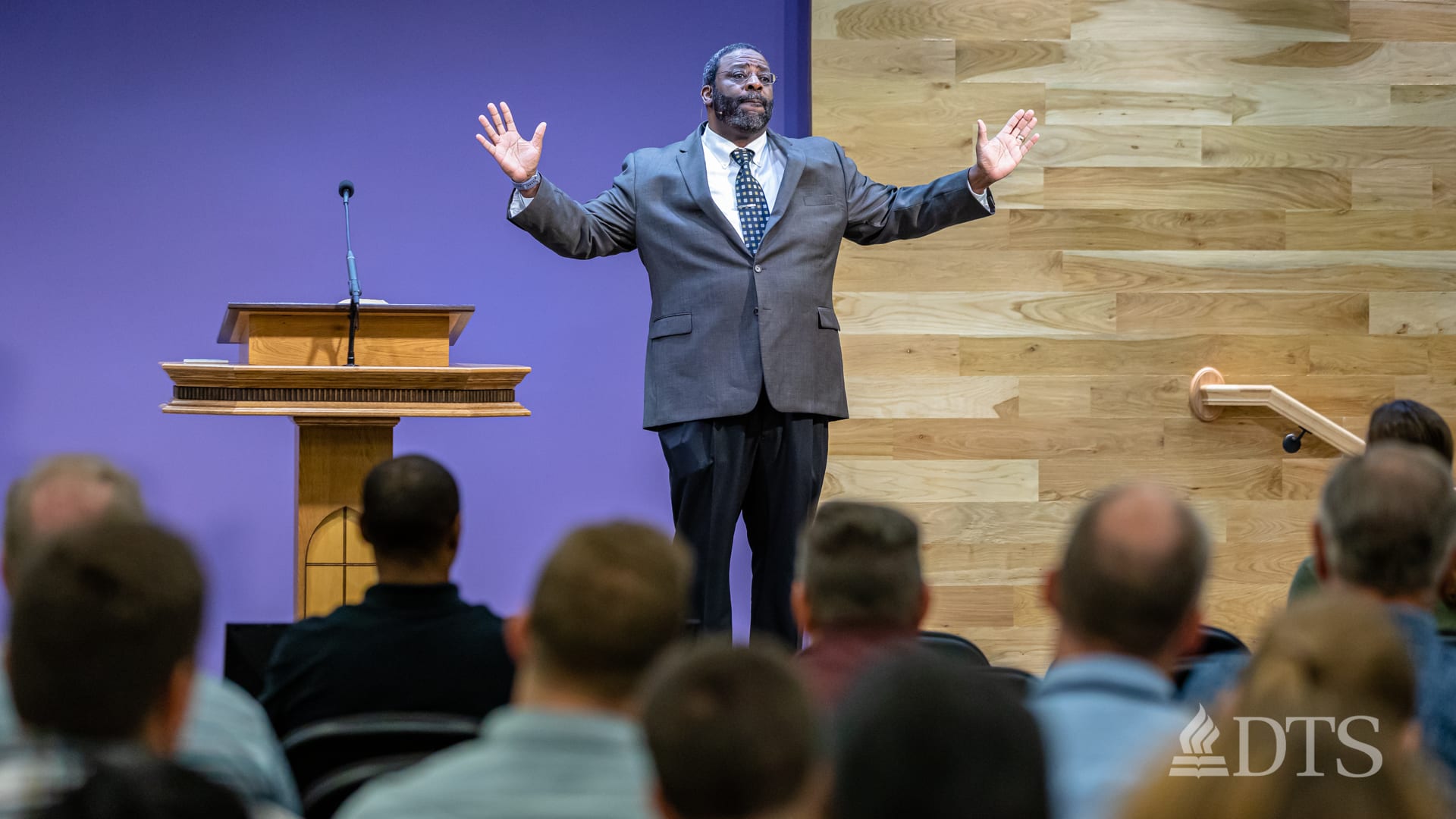 man standing next to podium speaking at DTS Chapel