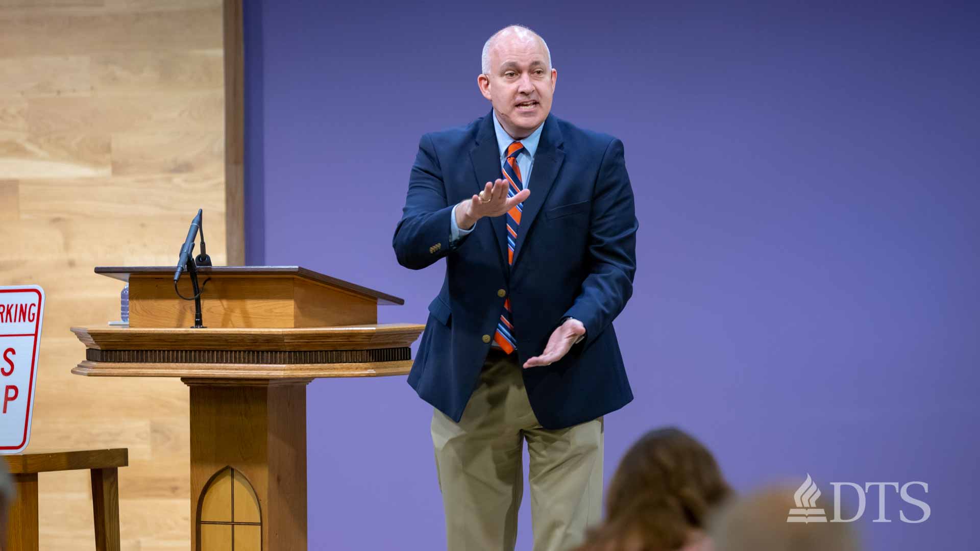 man standing next to podium speaking at DTS Chapel
