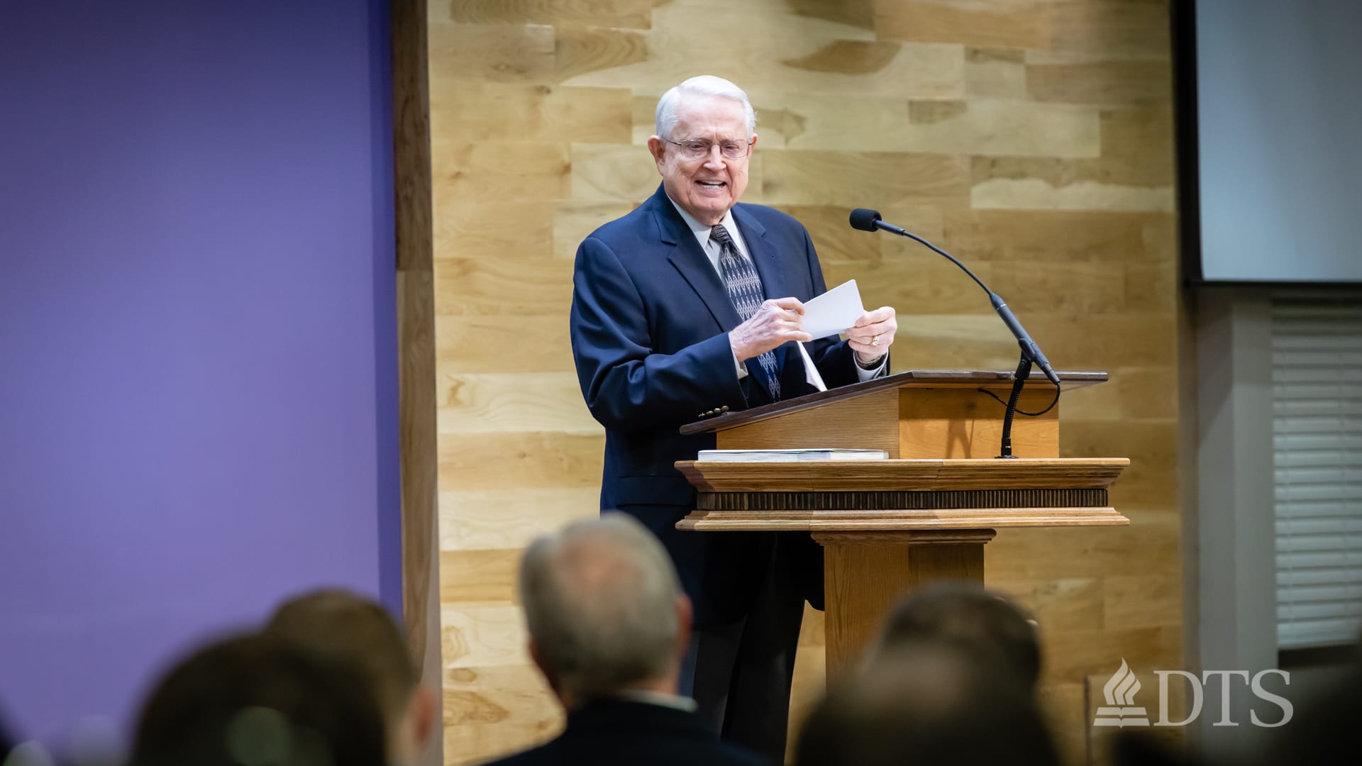Dr. Chuck Swindoll standing at podium speaking at DTS Chapel