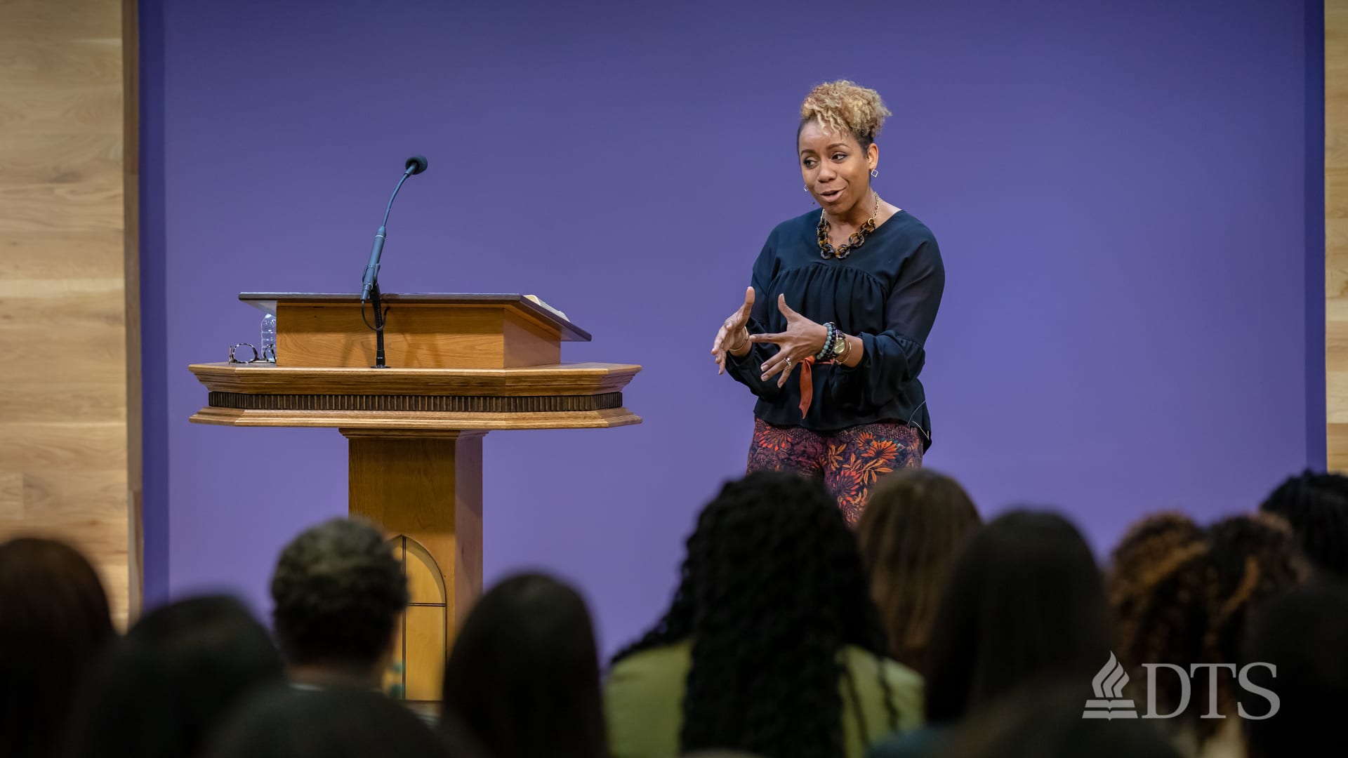 woman standing at podium speaking at DTS Chapel