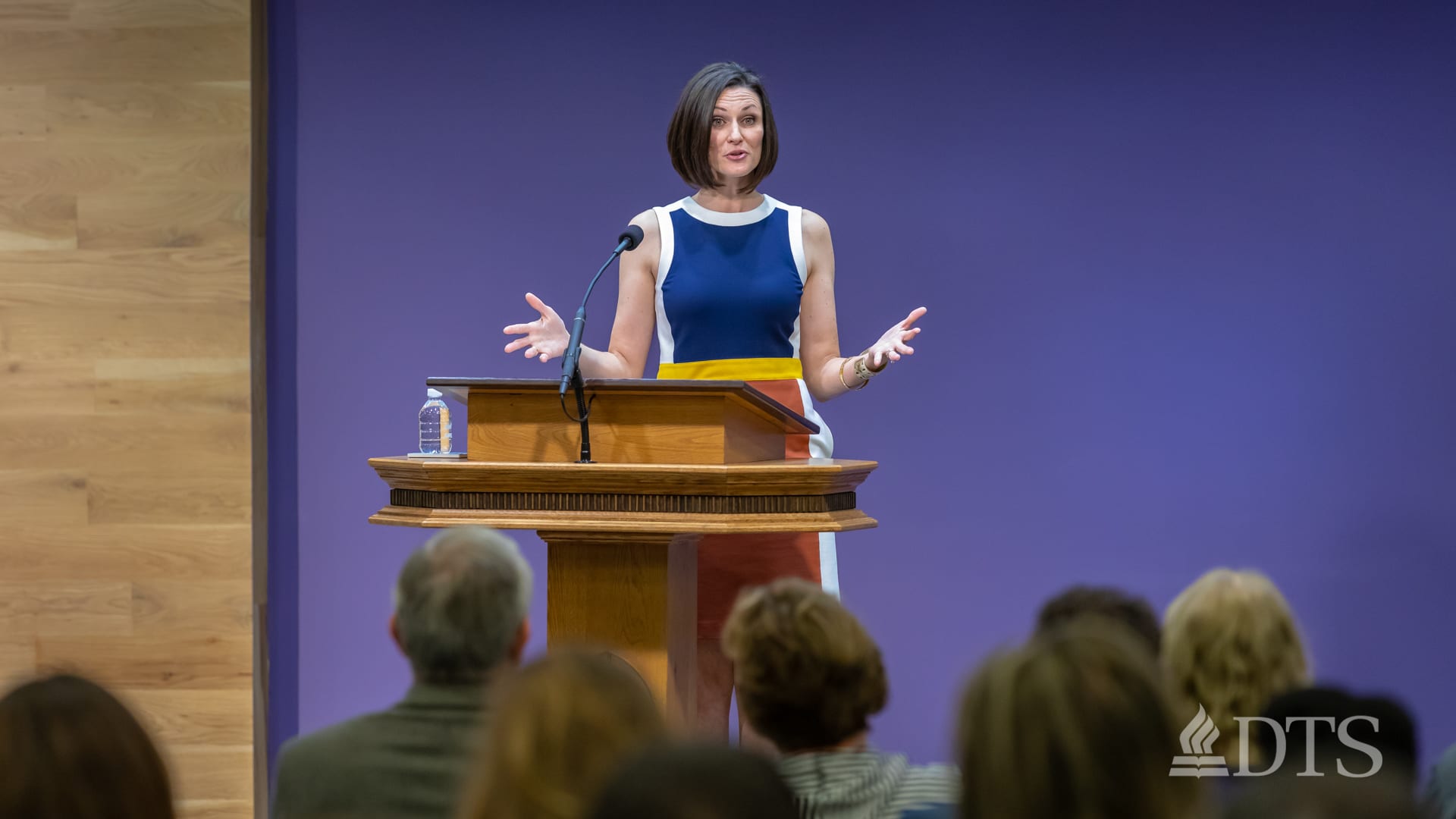 woman standing at podium speaking at DTS Chapel
