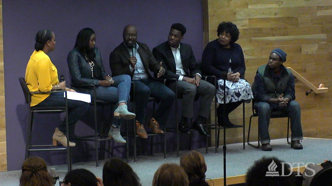 Group of men and women seated in stools on stage during a panel discussion at DTS Chapel