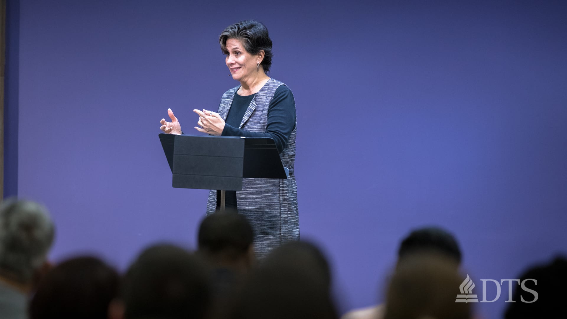 woman standing at podium speaking at DTS Chapel