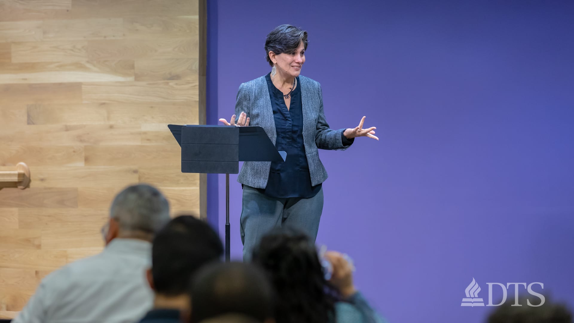 woman standing at podium speaking at DTS Chapel
