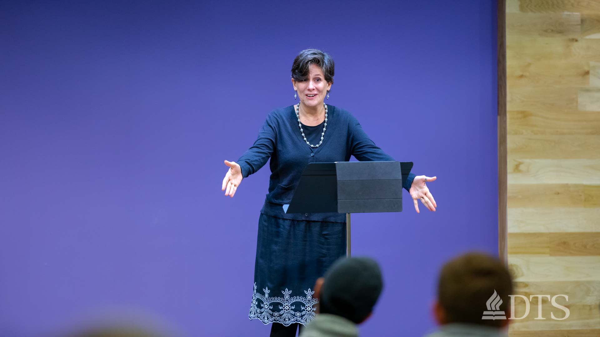 woman standing at podium speaking at DTS Chapel