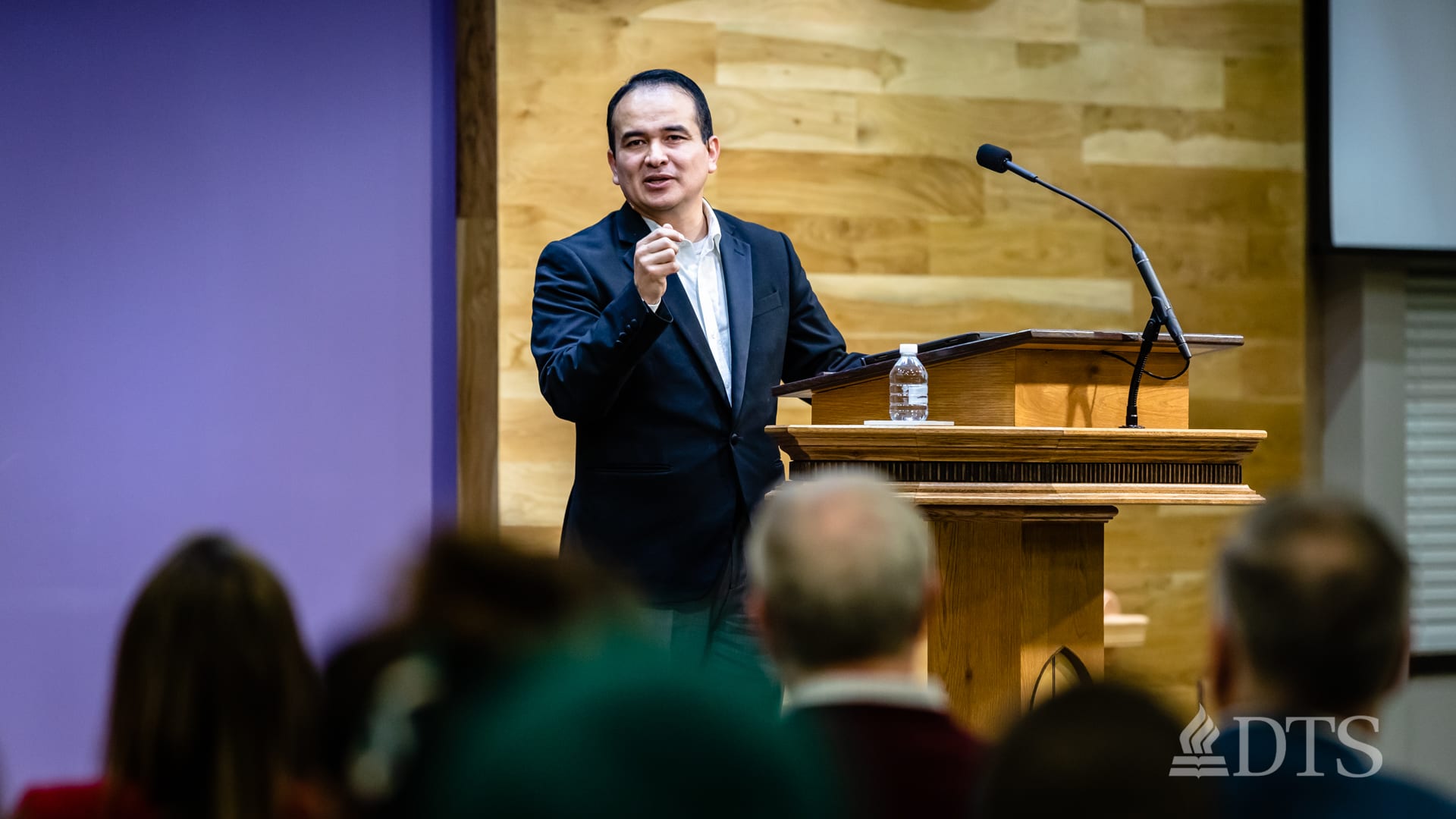 man standing at podium speaking at DTS Chapel