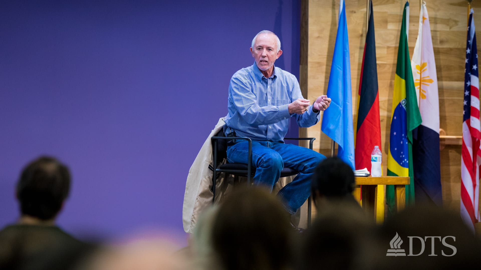 man seated on stage speaking at DTS WEC Week