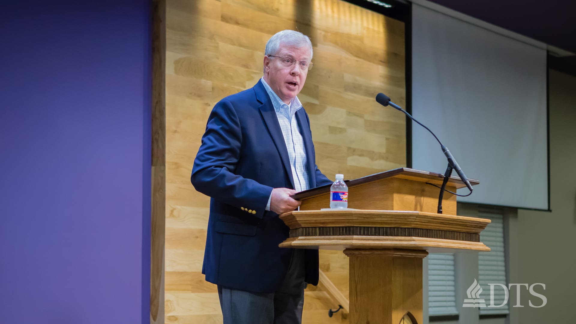 man standing at podium speaking at DTS Chapel