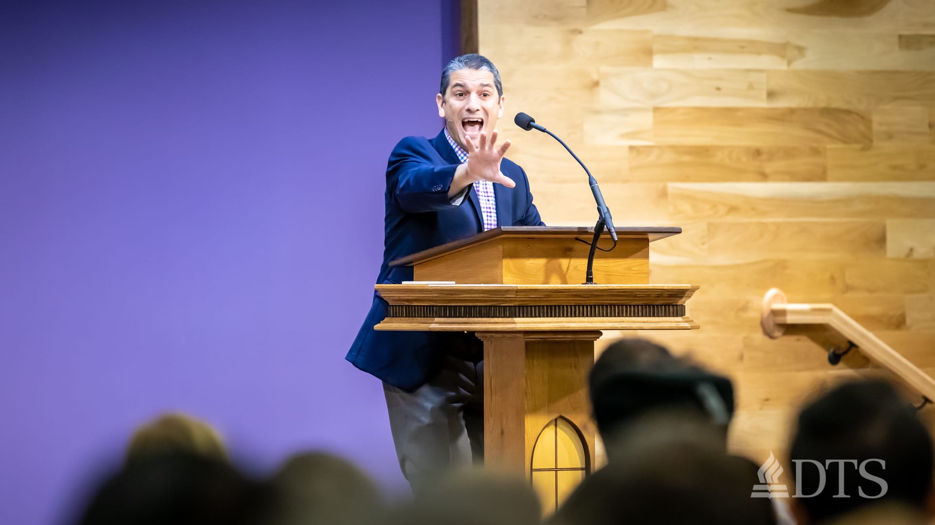 man standing at podium with arm outstretched while speaking at DTS Chapel