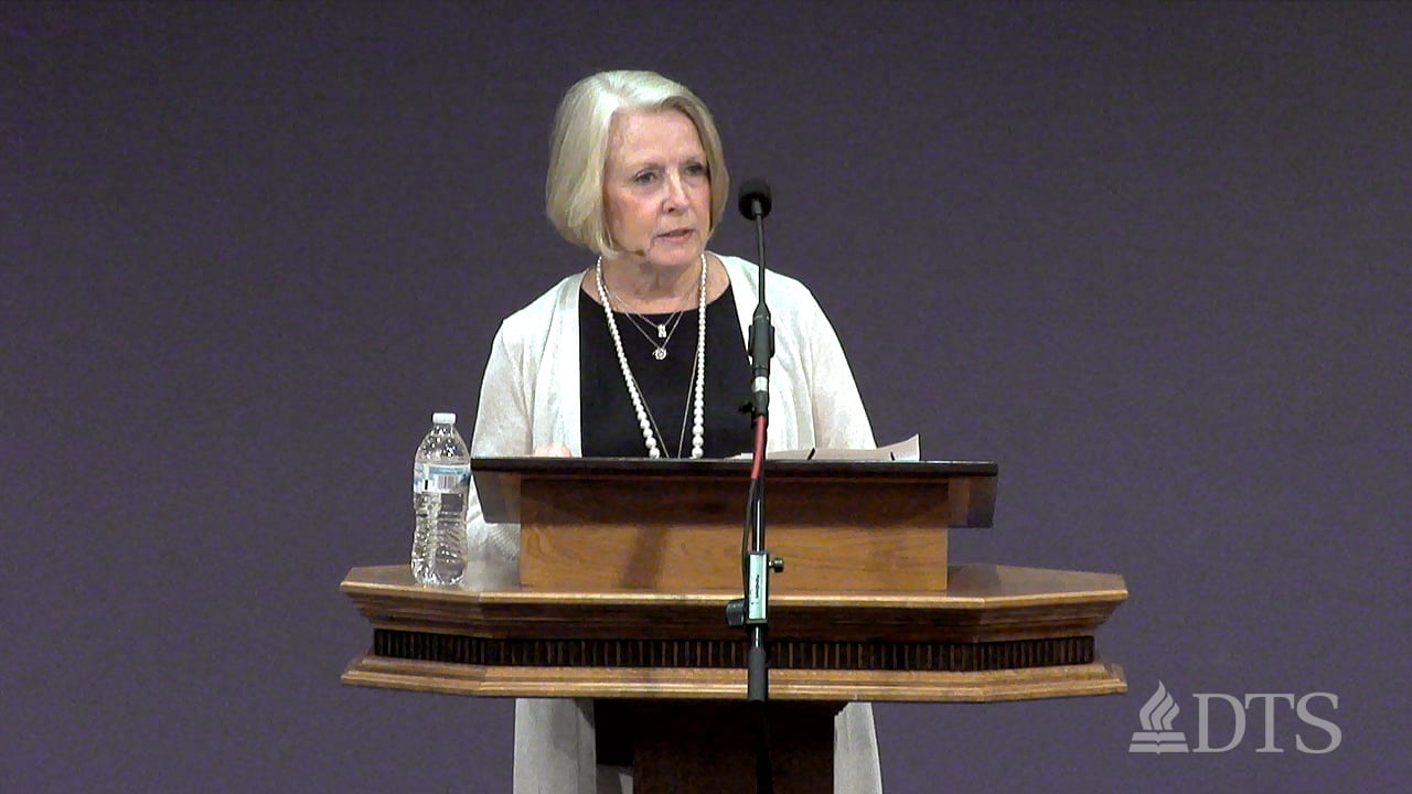 woman standing at podium speaking at DTS Chapel