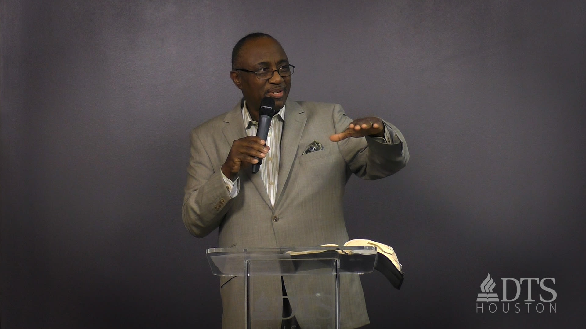 man standing at podium with arm raised while speaking at DTS Chapel