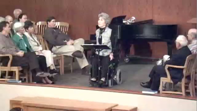 Joni Eareckson Tada seated in center of stage while speaking at DTS Chapel