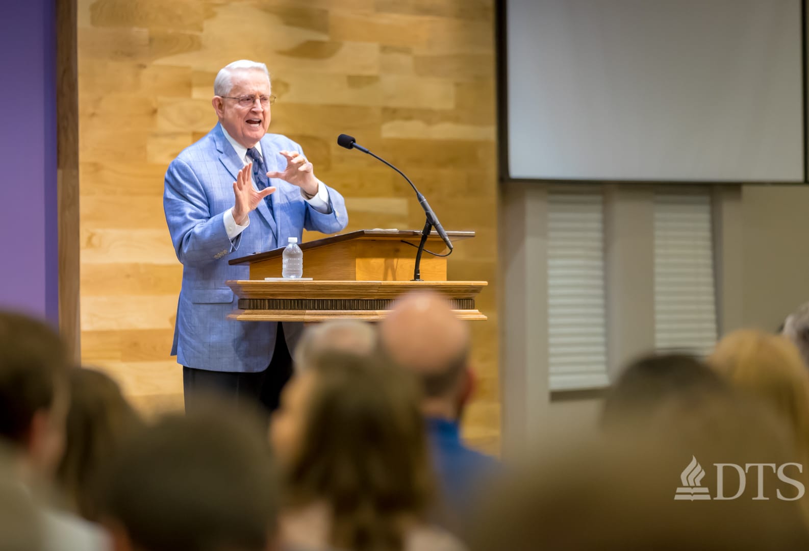 Dr. Chuck Swindoll standing at podium speaking at DTS Chapel