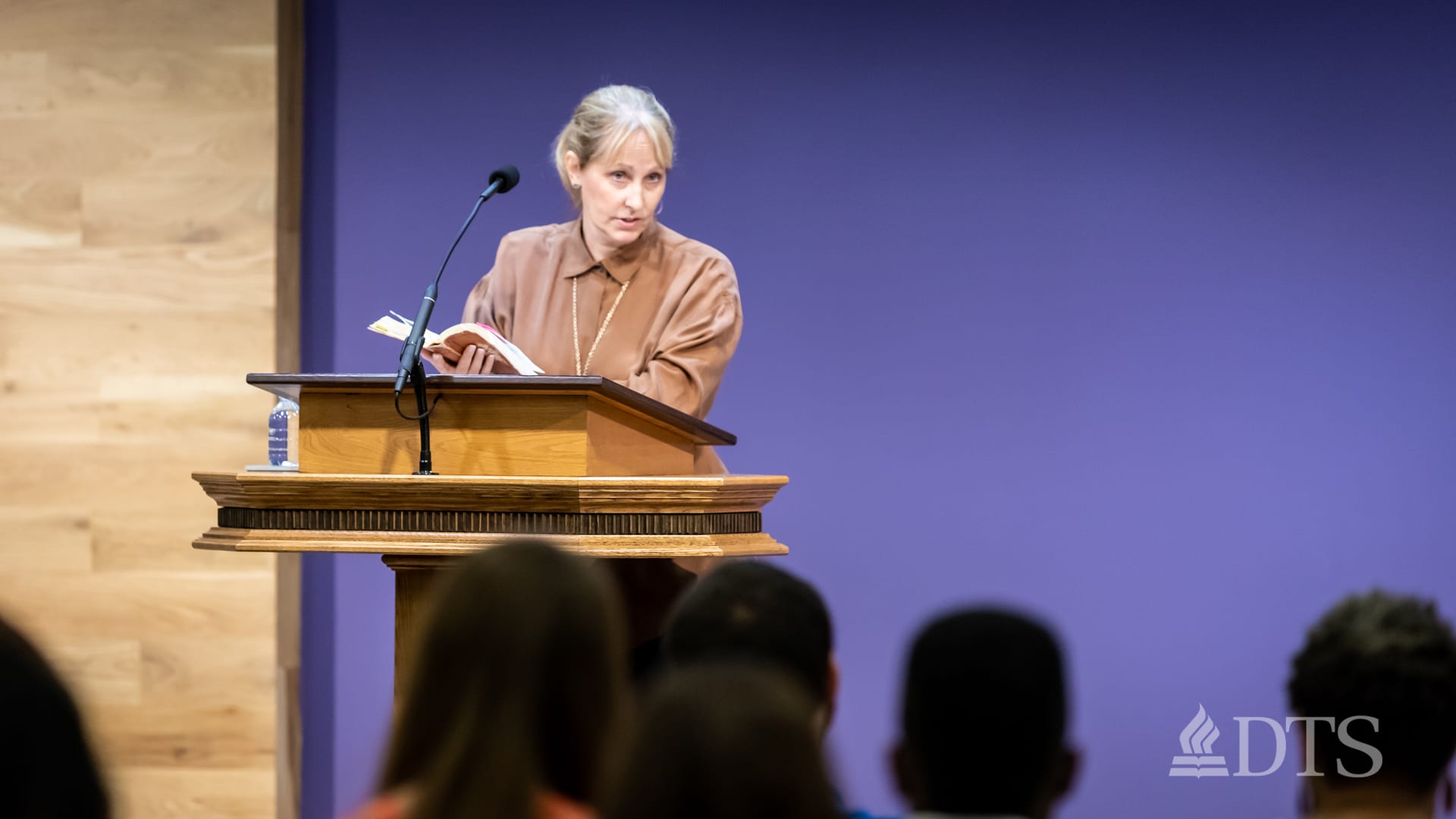 Dr. Sandra Glahn standing at podium speaking at DTS Chapel