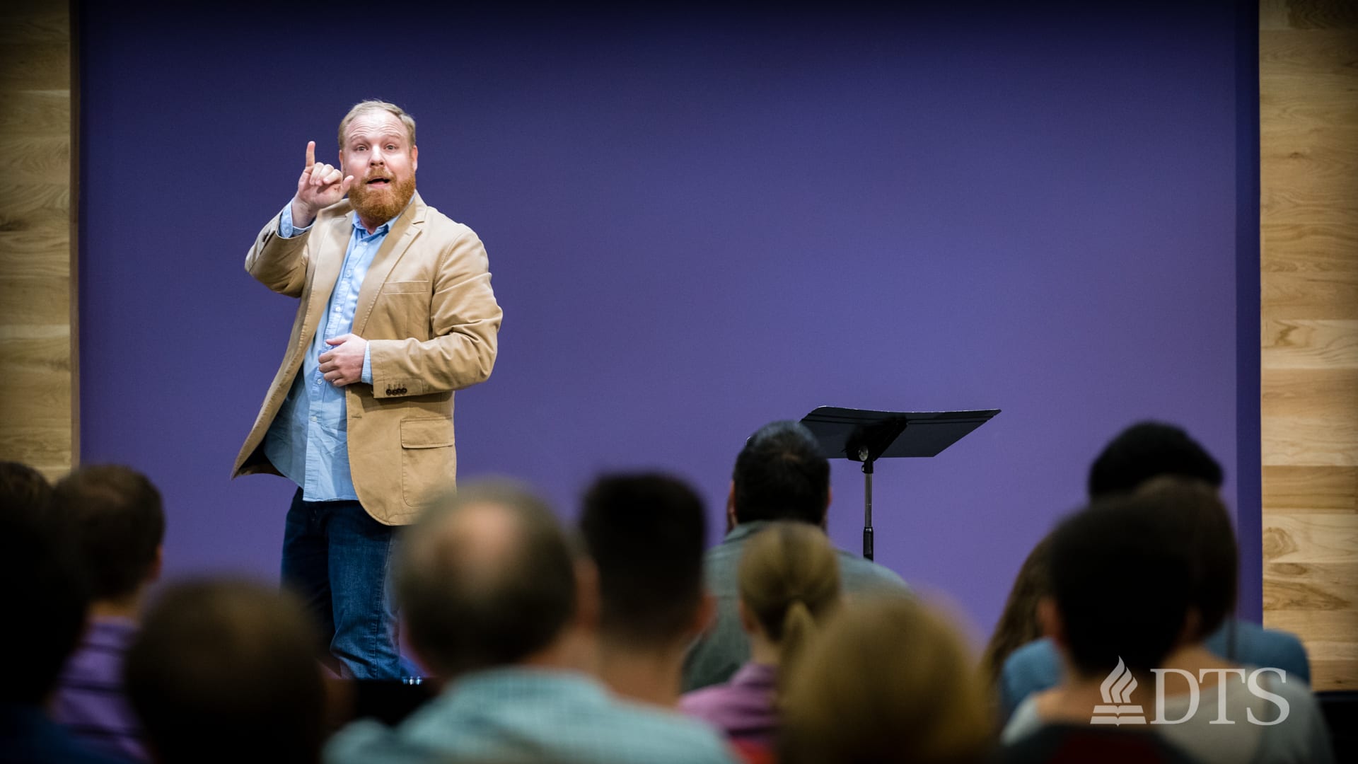 man standing on stage speaking in ASL at DTS Chapel