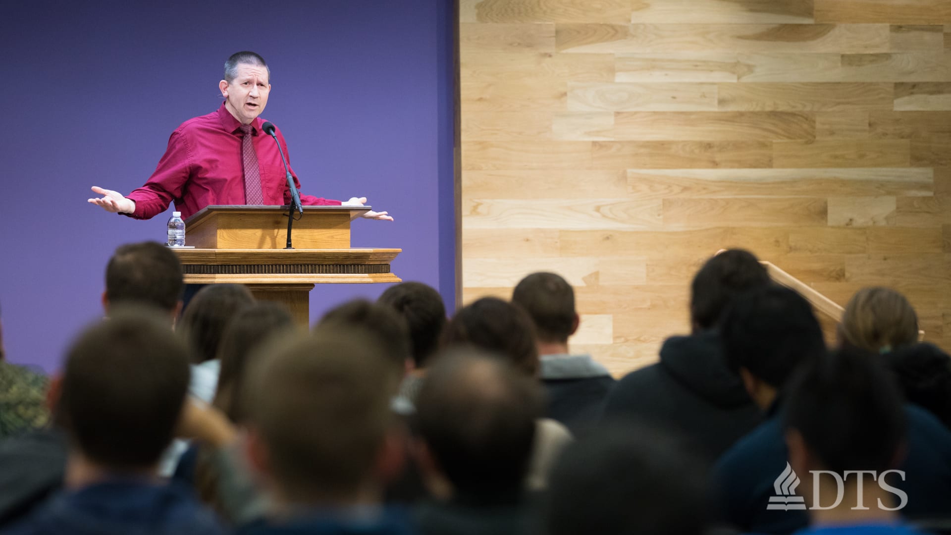 man standing at podium speaking at DTS Chapel