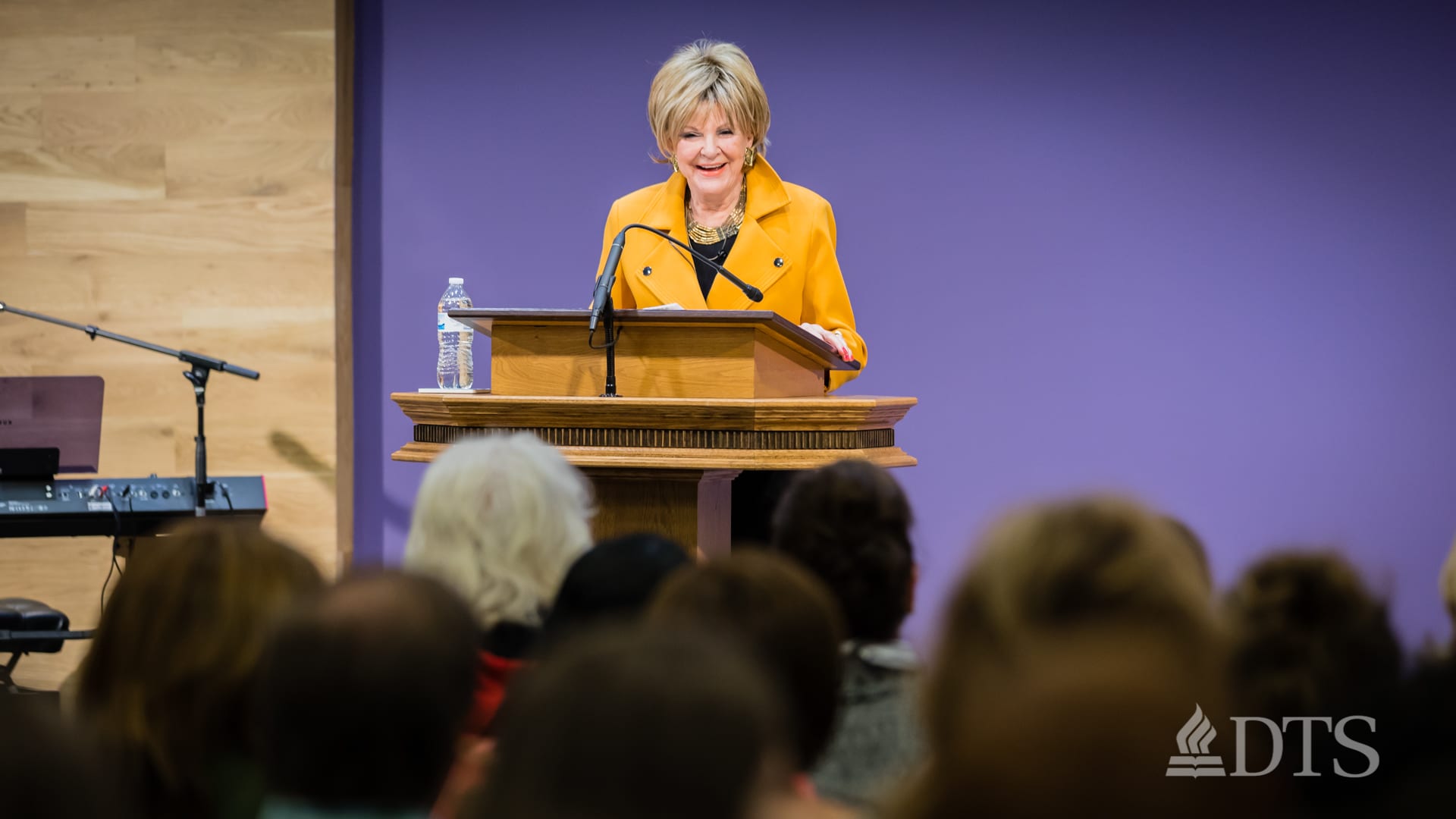 woman standing at podium speaking at DTS Chapel