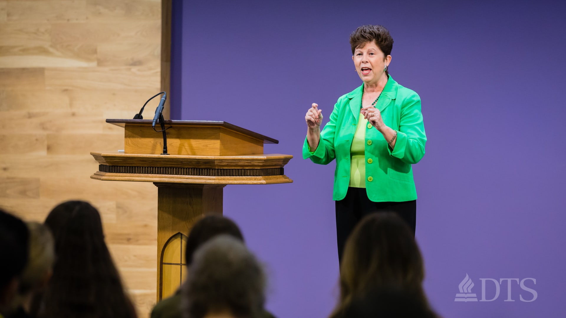Dr. Sue Edwards standing at podium speaking at DTS Chapel