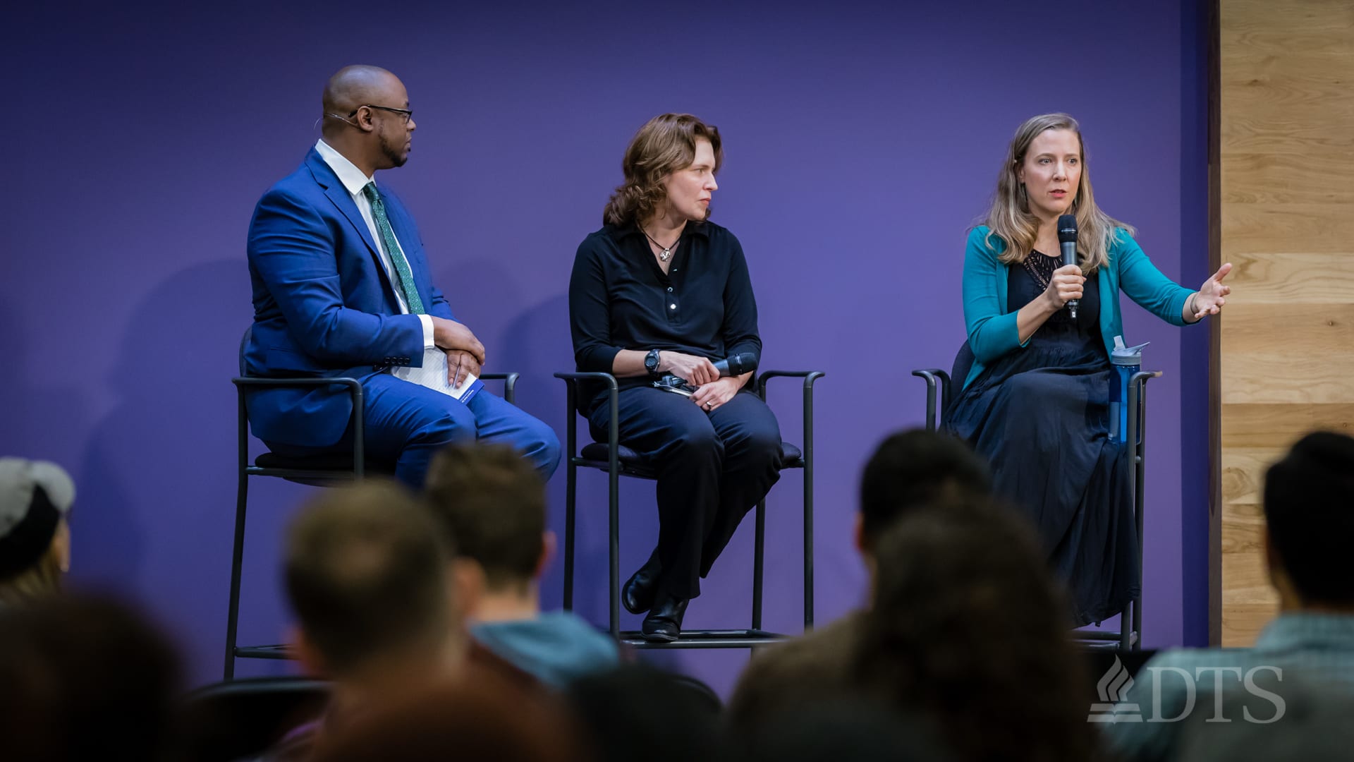 man and women seated in stools on stage during panel discussion in DTS Chapel