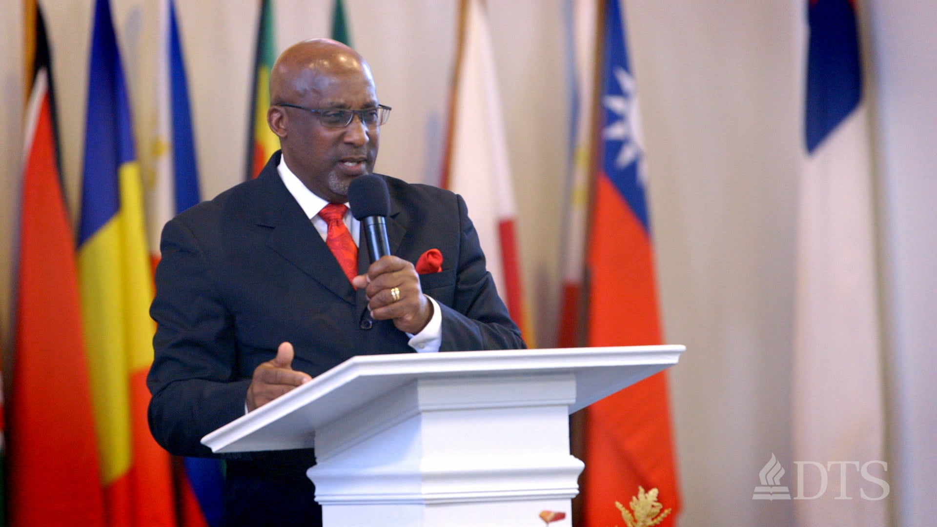 Dr. Bernard Fuller standing at podium speaking into microphone