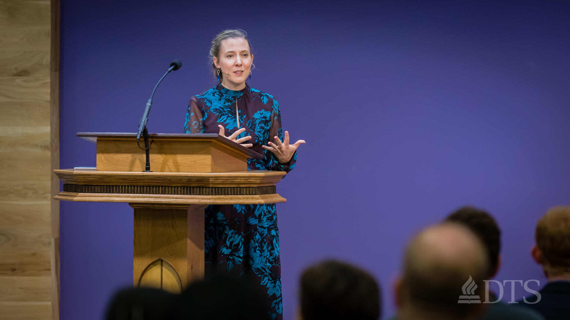 woman standing at podium speaking at DTS Chapel