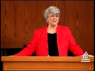 woman standing at podium speaking at DTS Chapel