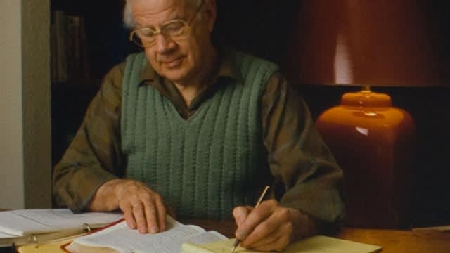 Dr. Dwight Pentecost studying the Bible at his desk