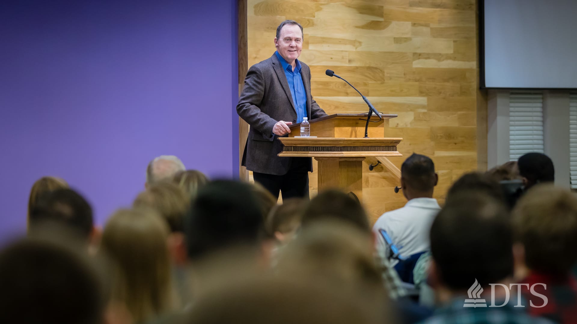 man standing at podium speaking at DTS Chapel