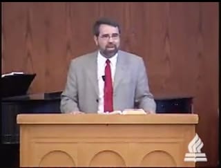 man standing at podium speaking at DTS Chapel
