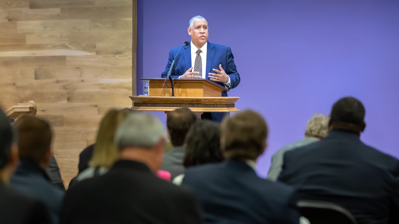 Robert Crummie speaking at a podium during DTS Chapel