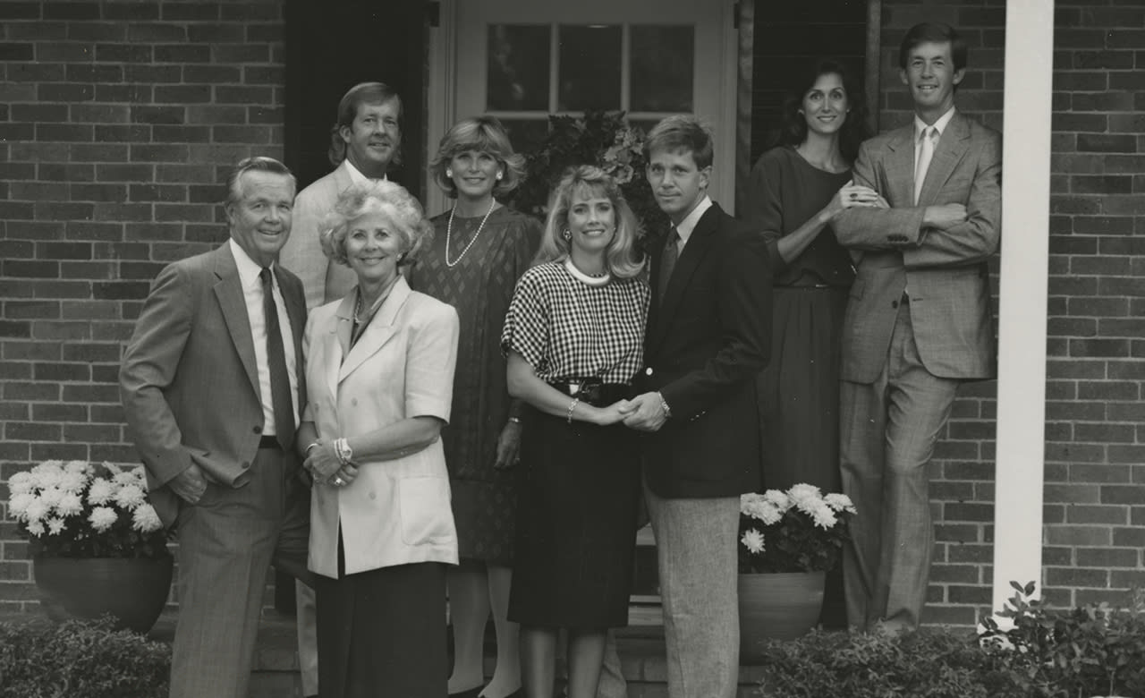 Jack Turpin posing on a porch with his wife and adult children