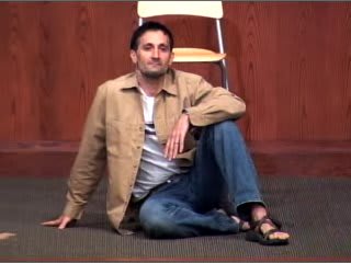 man seated on floor in front of chair
