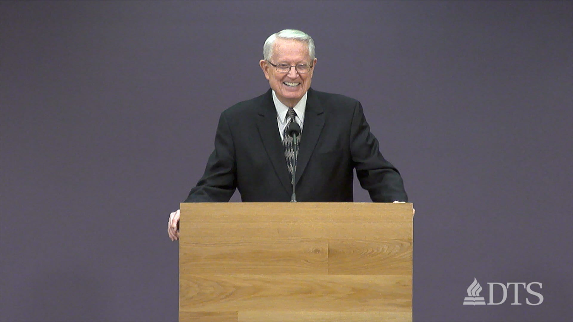 Dr. Chuck Swindoll standing at podium speaking at DTS Chapel