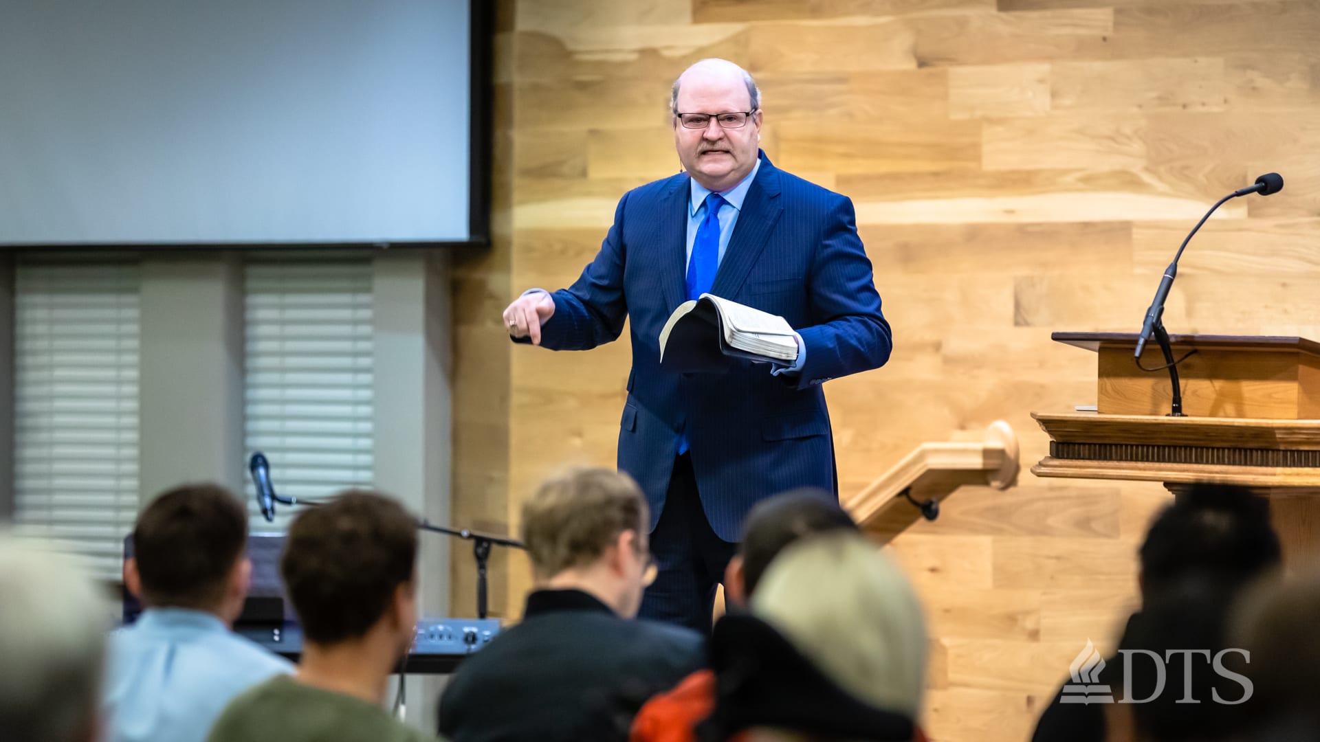 man standing near podium while speaking at DTS Chapel