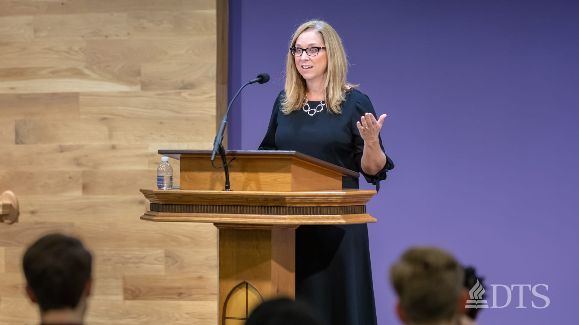 woman standing at podium speaking at DTS Chapel