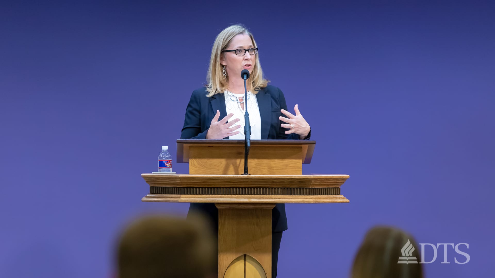 woman standing at podium speaking at DTS Chapel