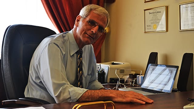 DTS alum Dr. Imad Shehadeh seated at an office desk