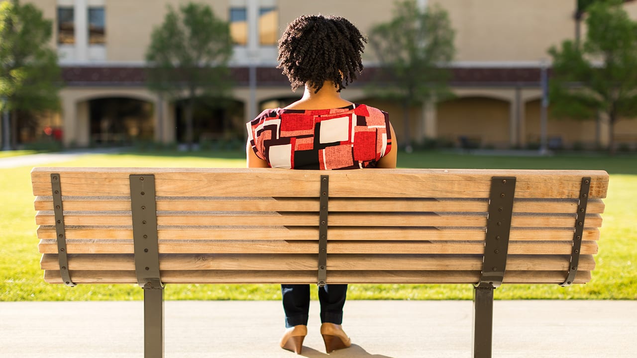 Margaret seated on a bench overlooking the DTS lawn